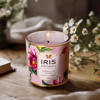 IRIS Botanics votive glass candle beside daisies